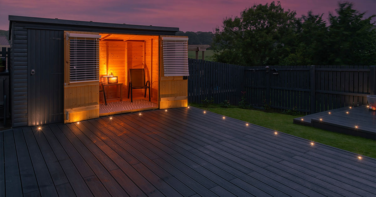 Illuminated cabin on composite deck against sunset sky