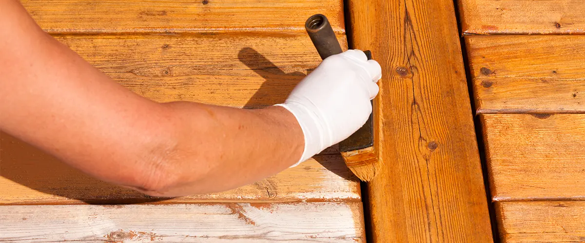 Wooden deck maintenance apply stain on decking