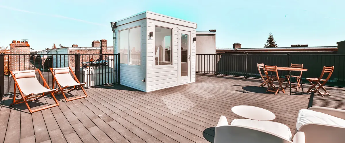 Spacious rooftop deck with lounge chairs and seating area under a clear sky