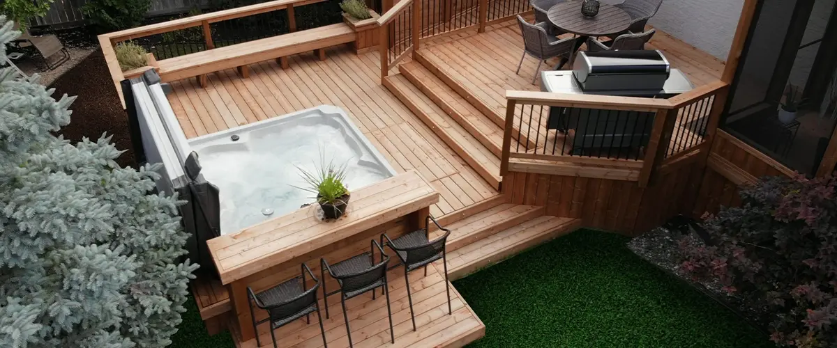 Aerial view of custom wood deck with hot tub, seating, and privacy screen.