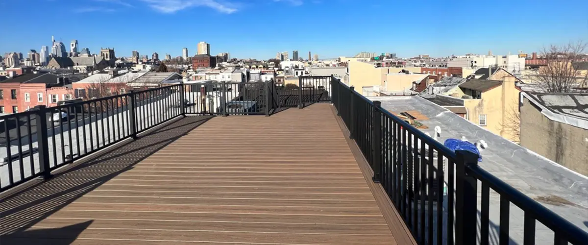 Rooftop deck with expansive city skyline view, featuring modern railing and composite decking