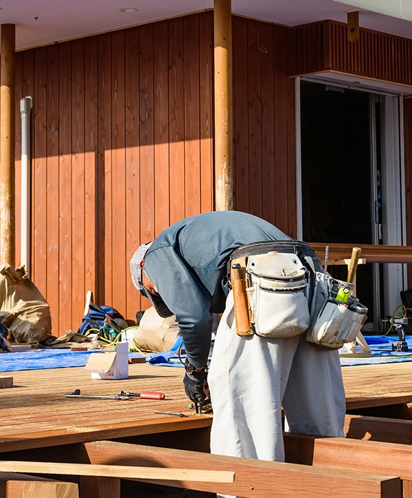 A worker with tools doing deck repair services in Fort Washington