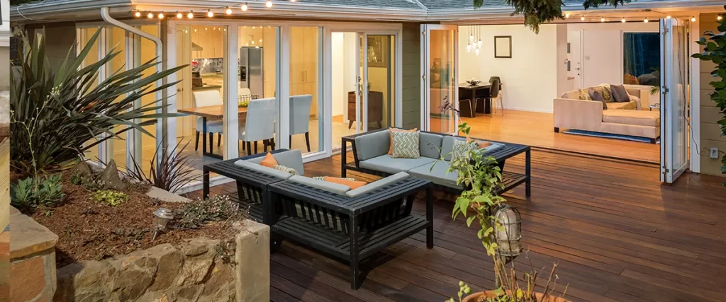 Modern backyard patio setup after professional deck repair, featuring clean wood finish and open indoor-outdoor flow.